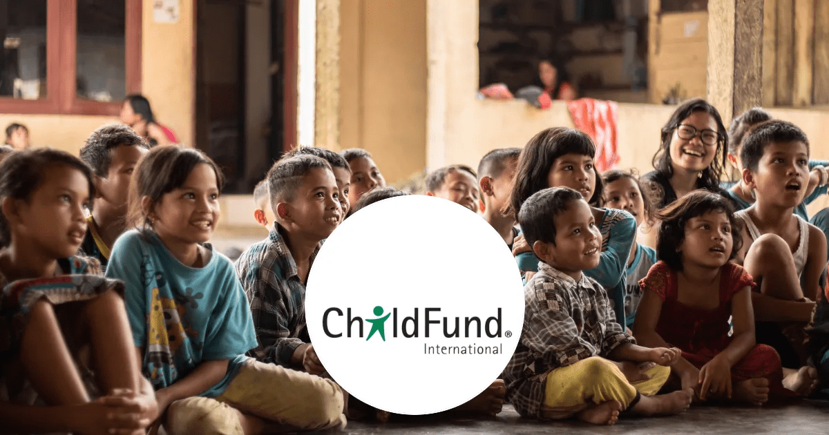 Children sitting on the floor in a learning environment with the Child Fund Logo overlapping